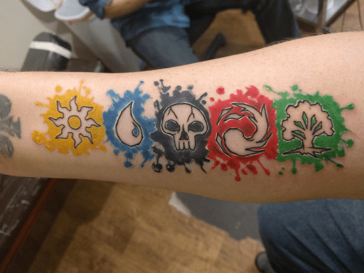 Color Splash and Negative Space Mana Symbols tattoo